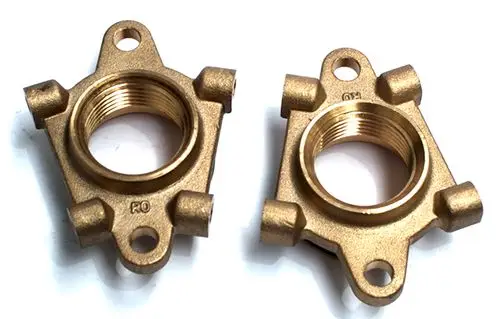 Zwei goldfarbene Doppelflansch-Elemente von Daikin mit Innengewinde, hergestellt aus Metall, zur Verwendung in Fußbodenheizungssystemen.